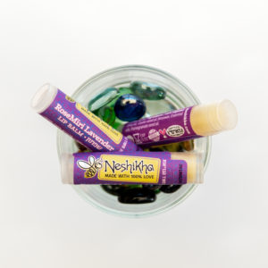 3 lip balm tubes in a glass bowl with stones